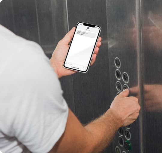 man entering elevator checking phone