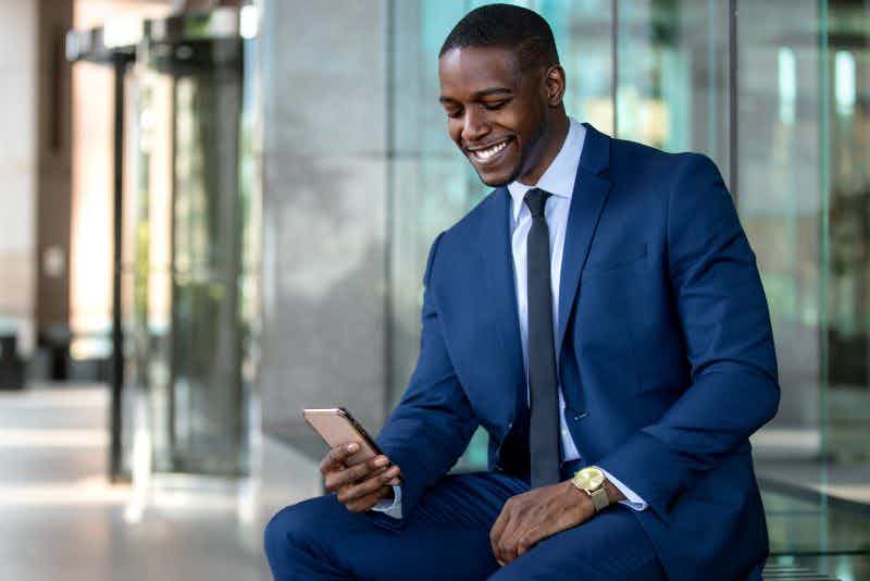 person wearing a suit uses a smartphone for office productivity